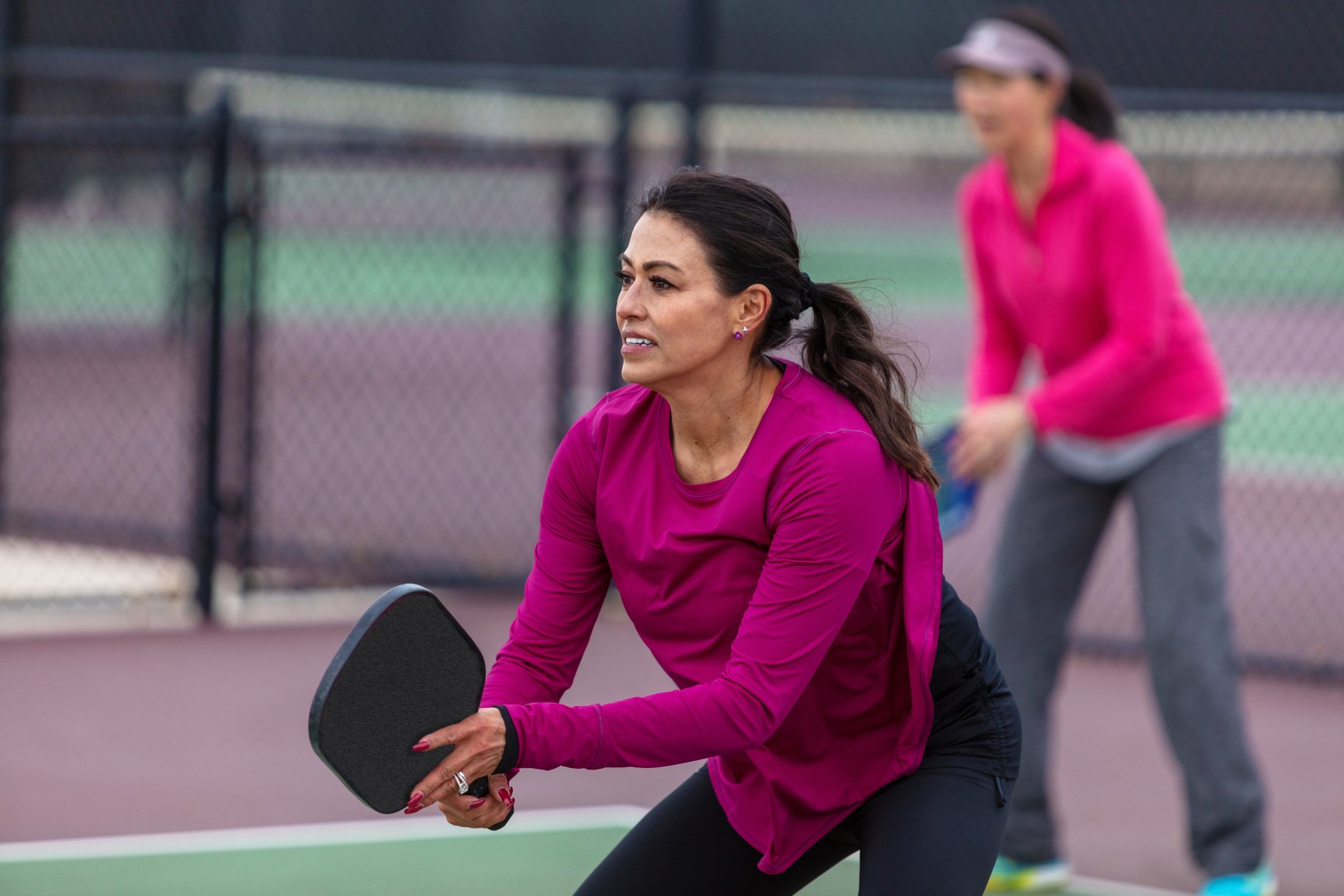 Mixed Ethnic Group of Active Retired Women Playing Pickleball Outdoors